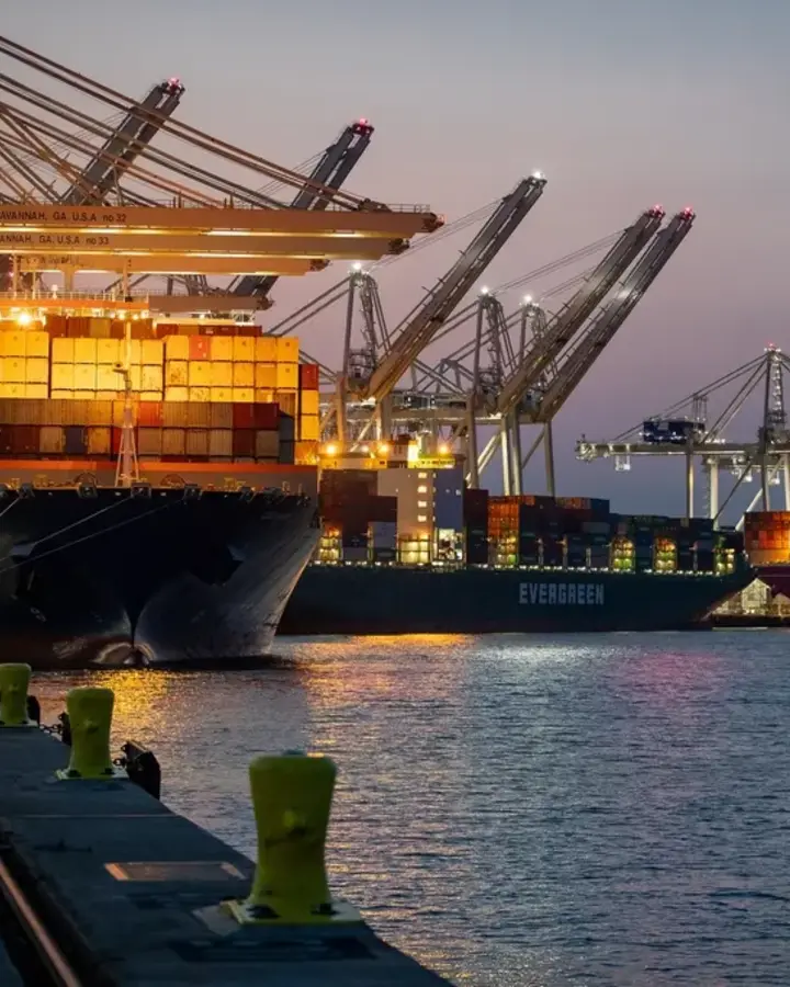 Container ships docked at a port at dusk