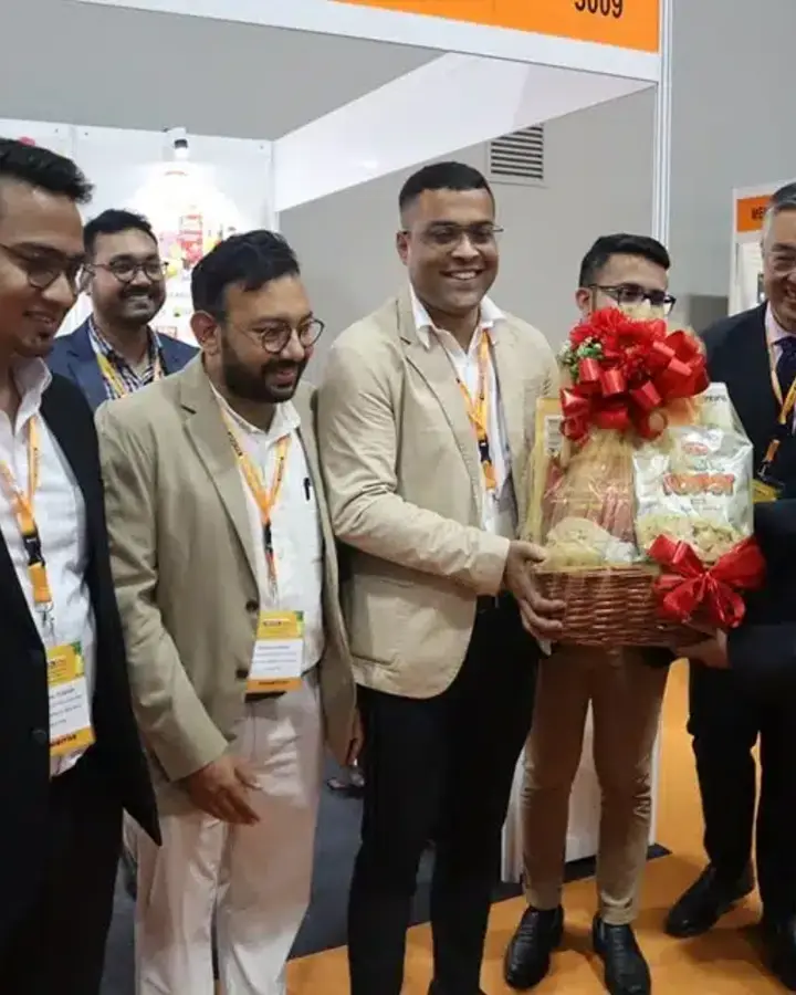 The Agroverse team presenting a gift basket to guests at an international food fair