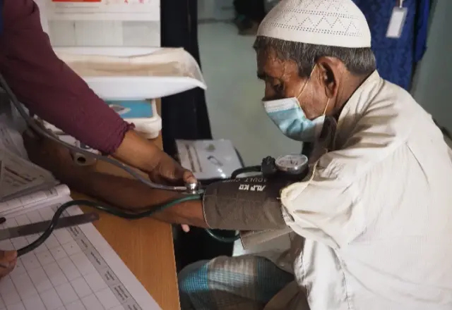 A health worker checking a patient's blood pressure